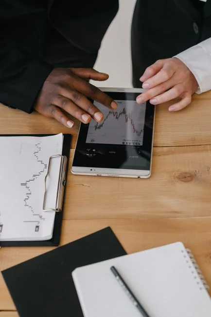 hero-img A modern workspace showing hands analyzing marketing data on a laptop and paper documents.